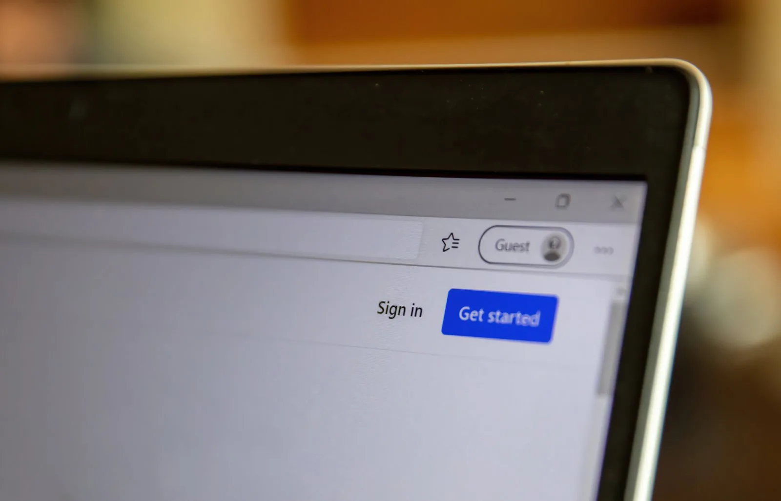 Close-up of a laptop browser with 'Guest' label, Sign in, and blue Get started button.